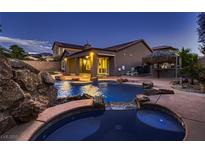 Beautiful backyard pool with hot tub, rock features, and tiki bar create an outdoor oasis at 2764 Kilwinning Dr, Henderson, NV 89044