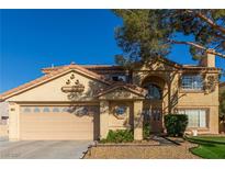 Charming two-story home features a well-manicured lawn and a classic, neutral-toned exterior, enhancing its curb appeal at 744 Spruce Tree Cir, Henderson, NV 89014