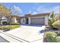 Charming single-story home with a well-manicured lawn, desert landscaping, and a spacious three-car garage at 10555 Garden Rose Dr, Las Vegas, NV 89135