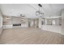 Bright, open-concept living room features a fireplace, custom built-ins, and luxury vinyl plank flooring at 2603 Savannah Springs Ave, Henderson, NV 89052