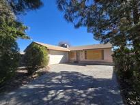 Single story home with a concrete driveway, front lawn and an attached garage with a two-car capacity at 4013 El Camino Ave, Las Vegas, NV 89102