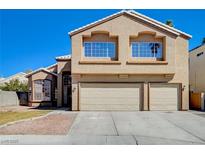 Two-story home featuring a three car garage, manicured front yard and tasteful desert landscaping at 4860 Contento Cir, North Las Vegas, NV 89031
