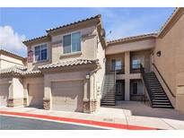 Inviting condo exterior featuring a private garage and a convenient stairway to upper-level residences at 6680 Abruzzi Dr # 102, North Las Vegas, NV 89084