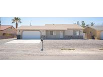Single-story home featuring a neutral color scheme, two-car garage, and xeriscaped front yard at 811 Lone Pine Rd, Pahrump, NV 89048