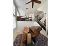 Spacious living room with beautiful piano and ceiling fan at 8426 Sluman Ct, Las Vegas, NV 89128