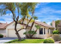 Charming one-story home featuring a two-car garage, lush landscaping, and a beautiful terracotta tile roof at 8582 Manalang Rd, Las Vegas, NV 89123