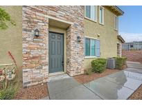 Inviting townhome featuring a stone facade and a well-manicured lawn at 965 Nevada State Dr # 8202, Henderson, NV 89002