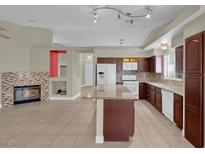 Spacious kitchen featuring dark wood cabinets, white appliances, and an island with granite countertops at 8217 Ashkum Ave, Las Vegas, NV 89149