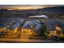 Stunning exterior showcasing a well-manicured lawn, complemented by scenic views of a tranquil lake and majestic mountains at 13 Porto Malaga St, Henderson, NV 89011