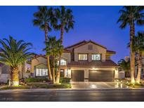 Beautiful two-story home with a three-car garage and palm trees lining the front at twilight at 2232 Barchetta Dr, Las Vegas, NV 89134