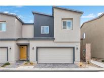 Modern townhouse with a neutral color scheme, attached garage, and well-maintained front yard at 4125 Venus Falls Ave, North Las Vegas, NV 89084