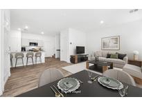 Bright, open-concept living room featuring a modern kitchen with an island and a cozy dining area at 4125 Venus Falls Ave, North Las Vegas, NV 89084