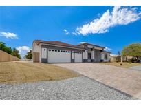 Beautiful home exterior featuring a three-car garage and a spacious driveway at 5601 Mary Lou St, Pahrump, NV 89061