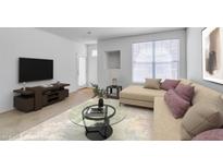 Bright living room with beige sofa, large window, and stylish glass coffee table at 5855 Valley Dr # 2020, North Las Vegas, NV 89031