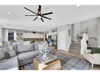 Bright and spacious living room featuring a ceiling fan, modern decor, and seamless access to the kitchen at 632 Loyalty Ct, Henderson, NV 89011
