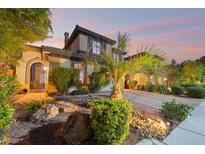 Charming two-story home featuring a well-manicured yard, desert landscaping, and a warm, inviting facade at dusk at 8224 Chimney Bluffs St, North Las Vegas, NV 89085