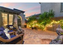 Cozy outdoor patio featuring wicker furniture, ambient lighting, and beautiful sunset view at 8224 Chimney Bluffs St, North Las Vegas, NV 89085