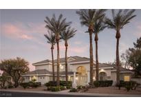 Elegant home featuring lush landscaping, palm trees, and a circular window, perfect for luxury living at 1865 Woodhaven Dr, Henderson, NV 89074