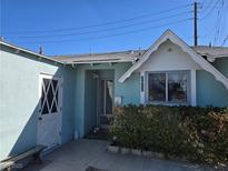 Charming exterior of a single-story home featuring a unique diamond pane door and an address marked above the window at 2012 Wendell Ave, Las Vegas, NV 89101