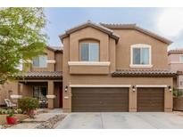 Two-story home featuring a three-car garage, desert landscaping, and a covered front porch at 231 Pioneers Peak Ave, Henderson, NV 89002