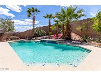 Beautiful pool featuring tropical landscaping and a serene waterfall feature at 231 Pioneers Peak Ave, Henderson, NV 89002