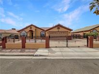 Charming tan single-story home featuring desert landscaping, iron gate, and a two-car garage at 4825 E Boston Ave, Las Vegas, NV 89104
