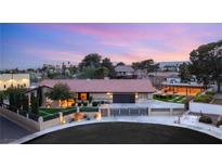 Expansive single-story home featuring a tile roof, manicured lawn, mature trees, and circular driveway at 6975 Darby Ave, Las Vegas, NV 89117