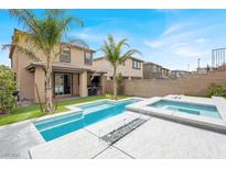 Inviting backyard featuring a modern pool, spa, outdoor kitchen, palm trees, and artificial turf at 12553 Skylight View St, Las Vegas, NV 89138