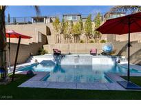 Inviting pool area with waterfall feature, surrounded by lush landscaping and comfortable seating at 12553 Skylight View St, Las Vegas, NV 89138