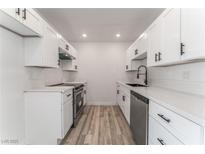 Updated kitchen featuring white cabinets, stainless steel appliances, and modern countertops at 2915 Cedar Ave # 12C, Las Vegas, NV 89101