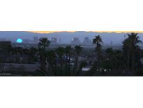Expansive city skyline view featuring palm trees and distant mountains at dusk at 6915 Cedar Basin Ave, Las Vegas, NV 89142