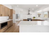 Bright kitchen features wood cabinets, stainless steel appliances, white subway tile, and stunning quartz countertops at 800 Anchor Dr, Henderson, NV 89015