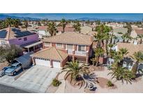 A two-story home with a three-car garage, desert landscaping, and a tan roof is seen from above at 1066 Aspen Valley Ave, Las Vegas, NV 89123