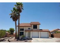 Two story home featuring a two car garage and complemented by lush palm trees at 3105 Palo Verde Dr, Laughlin, NV 89029