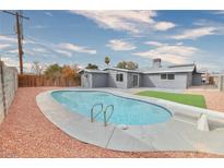 Inviting backyard pool with diving board, surrounded by concrete and gravel with a fenced perimeter at 3905 Casa Grande Ave, Las Vegas, NV 89102