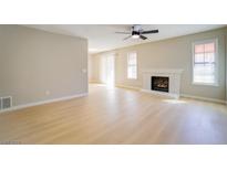 Bright living room with fireplace, ceiling fan, and wood-style flooring at 6649 W Tropicana Ave # 101, Las Vegas, NV 89103