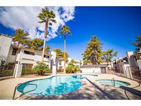 Community pool and hot tub surrounded by well-maintained landscaping and palm trees at 6649 W Tropicana Ave # 101, Las Vegas, NV 89103