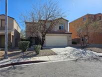 Two-story house with a well-maintained lawn, landscaping and attached two car garage at 9141 Iron Cactus Ave, Las Vegas, NV 89148