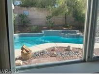 View of a refreshing in-ground pool with rock details and mature landscaping at 1297 Peppercorn Ave, Henderson, NV 89012