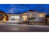Stunning modern home with a stylish stone facade, a glass garage door, and professionally landscaped yard at 148 Tre Pietre St, Henderson, NV 89011