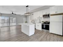 Modern kitchen features stainless appliances, island, sleek countertops, and ample storage space, seamlessly connected to the dining area at 1906 Palora Ave, Las Vegas, NV 89169