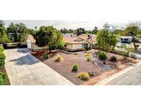 Charming single-story home features a low-maintenance desert landscape with gravel and mature trees, plus a wide driveway at 4343 Sharpshooter Ln, North Las Vegas, NV 89031