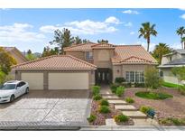 Charming two-story home with a terracotta roof, landscaped front yard, and a spacious three-car garage at 5205 Sandy Cactus Ln, Las Vegas, NV 89149