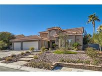 Charming two-story home boasts a clay tile roof, two car garage, and low maintenance desert landscaping at 5205 Sandy Cactus Ln, Las Vegas, NV 89149