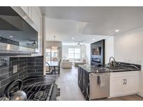 Modern kitchen with black and white finishes that flow into an open concept living and dining area at 8777 W Maule Ave # 3090, Las Vegas, NV 89148