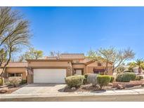 Charming single-story home with a neutral color scheme, tile roof, manicured landscaping, and an attached two-car garage at 10057 Bundella Dr, Las Vegas, NV 89134