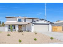 Charming two-story home with a white exterior, desert landscaping, and an attached two-car garage at 1435 Rawhide Rd, Boulder City, NV 89005