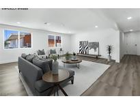 Bright, open living room with modern decor and wood-look floors offers a spacious design at 2729 Flower Ave, North Las Vegas, NV 89030