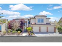 Charming two-story home with a three-car garage and well-manicured front yard landscaping and classic architectural details at 2875 Cooper Creek Dr, Henderson, NV 89074