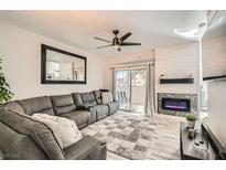 Cozy living room featuring a large sectional, fireplace, and access to a balcony with neighborhood views at 2975 Bluegrass Ln # 412, Henderson, NV 89074